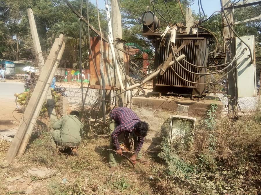 ವಿದ್ಯುತ್ ಪರಿವರ್ತಕವೊಂದರ ಸುತ್ತ ಸ್ವಚ್ಛ ಮಾಡುತ್ತಿರುವ ಸೆಸ್ಕ್ ಸಿಬ್ಬಂದಿ