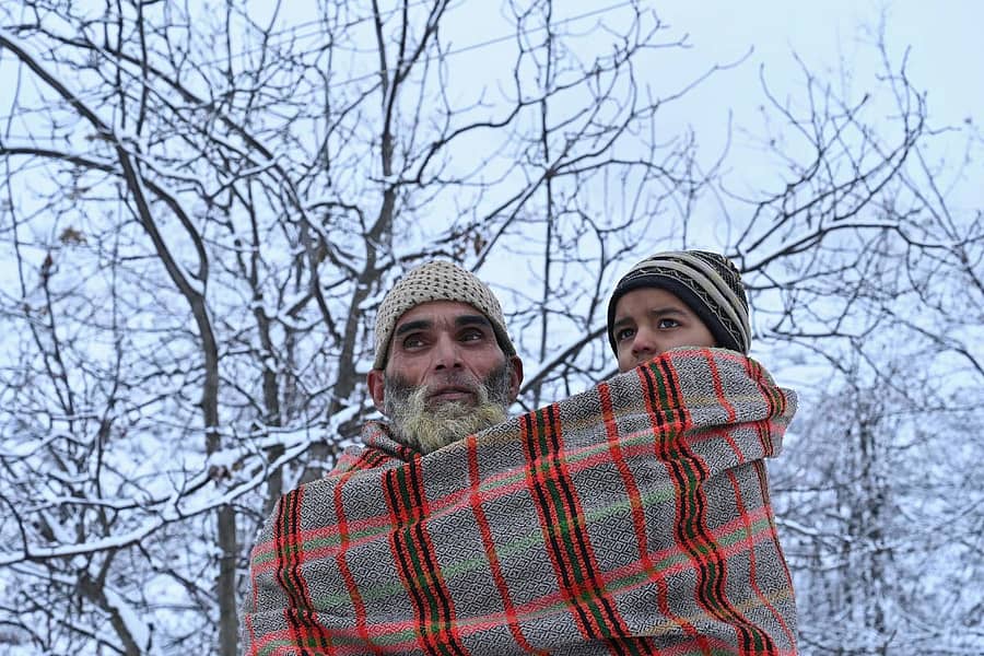 ಕಾಶ್ಮೀರದಲ್ಲಿ ಚಳಿಗೆ ನಡುಗುತ್ತಿದ್ದ ಮಗುವಿಗೆ ಅಜ್ಜನ ರಕ್ಷೆ (ಪಿಟಿಐ ಚಿತ್ರ).