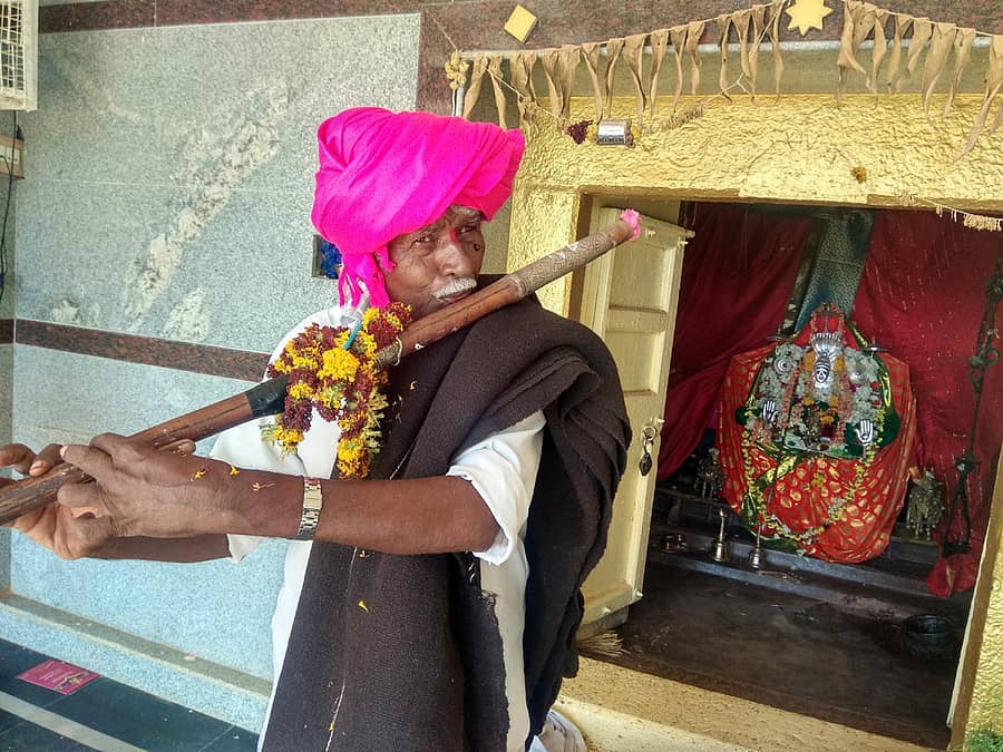 ಕರಿ ಕಂಬಳಿ ಹೊದ್ದು ಗಣೆ ಊದುತ್ತಿರುವ ಪೂಜಾರಿ ವೀರಣ್ಣ