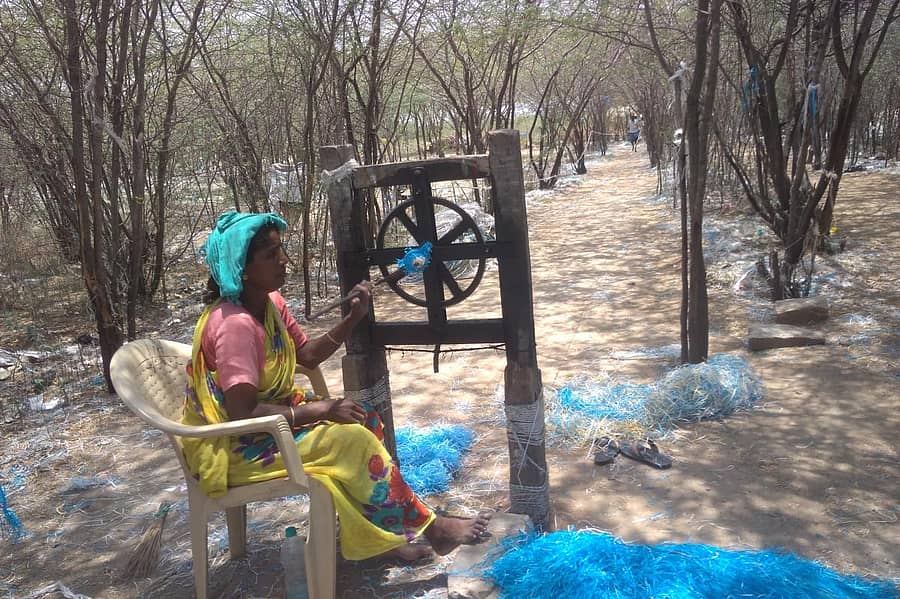 ರಾಟೆ ಮೂಲಕ ಪ್ಲಾಸ್ಟಿಕ್ ಗೋಣಿಚೀಲದಿಂದ ಹಗ್ಗ ತಯಾರಿಸುತ್ತಿರುವ ಮಹಿಳೆ