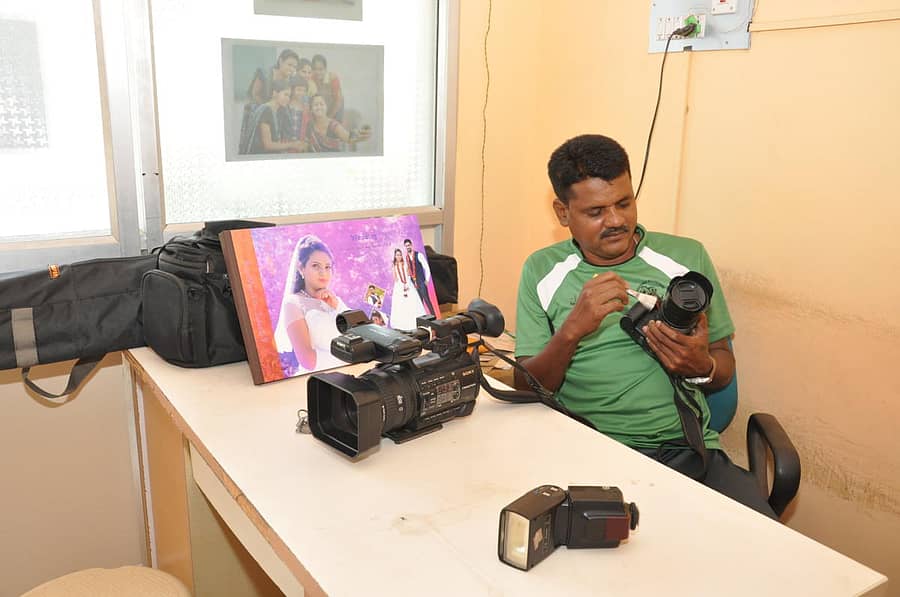 ಸ್ಟುಡಿಯೊದಲ್ಲಿ ಕ್ಯಾಮೆರಾವನ್ನು ಸ್ವಚ್ಛಗೊಳಿಸುವುದರಲ್ಲಿ ನಿರತ ಛಾಯಾಗ್ರಾಹಕ