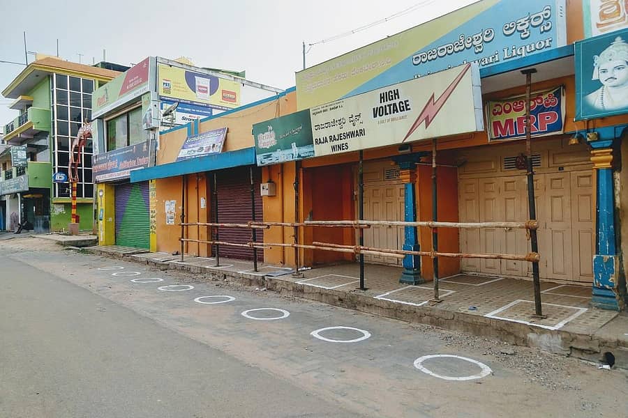 ಚಾಮರಾಜನಗರದ ಮದ್ಯದ ಅಂಗಡಿಯ ಎದುರು ತಡೆ ಬೇಲಿ ನಿರ್ಮಿಸಿ, ಅಂತರ ಕಾಯ್ದುಕೊಳ್ಳಲು ಗುರುತು ಮಾಡಿರುವುದು