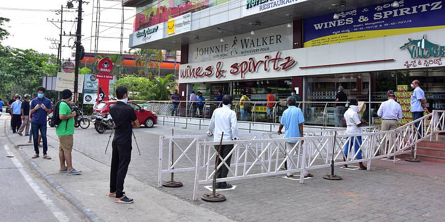 ಮಂಗಳೂರಿನ ಕದ್ರಿ ಮಲ್ಲಿಕಟ್ಟೆಯ ಮದ್ಯದ ಅಂಗಡಿ ಎದುರು ಸೋಮವಾರ ಬೆಳಿಗ್ಗೆ ಗ್ರಾಹಕರು ಮದ್ಯ ಖರೀದಿಗೆ ಸಾಲಾಗಿ ನಿಂತಿದ್ದ ದೃಶ್ಯ– ಪ್ರಜಾವಾಣಿ ಚಿತ್ರ