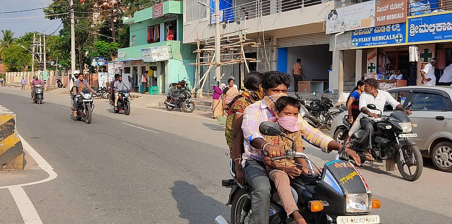 ಯಳಂದೂರು ಪಟ್ಟಣದಲ್ಲಿ ಗುರುವಾರ ದ್ವಿಚಕ್ರ ವಾಹನ ಸವಾರರು ಹೆಲ್ಮೆಟ್ ಬದಲು ಮಾಸ್ಕ್ ಧರಿಸಿ ಸಂಚರಿಸಿದರು