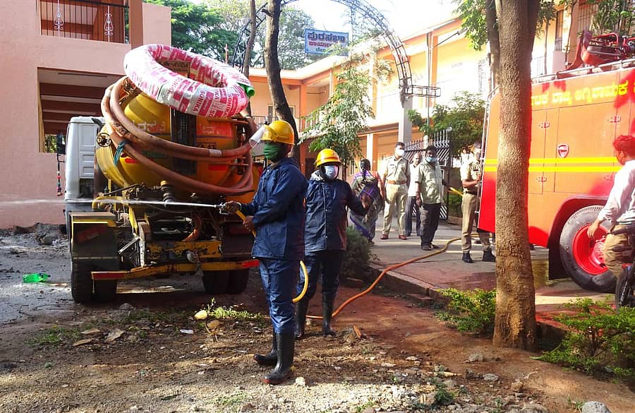 ಕ್ರಿಮಿನಾಶಕ ಸಿಂಪಡಿಸುತ್ತಿರುವ ಅಗ್ನಿಶಾಮಕ ದಳದ ಸಿಬ್ಬಂದಿ