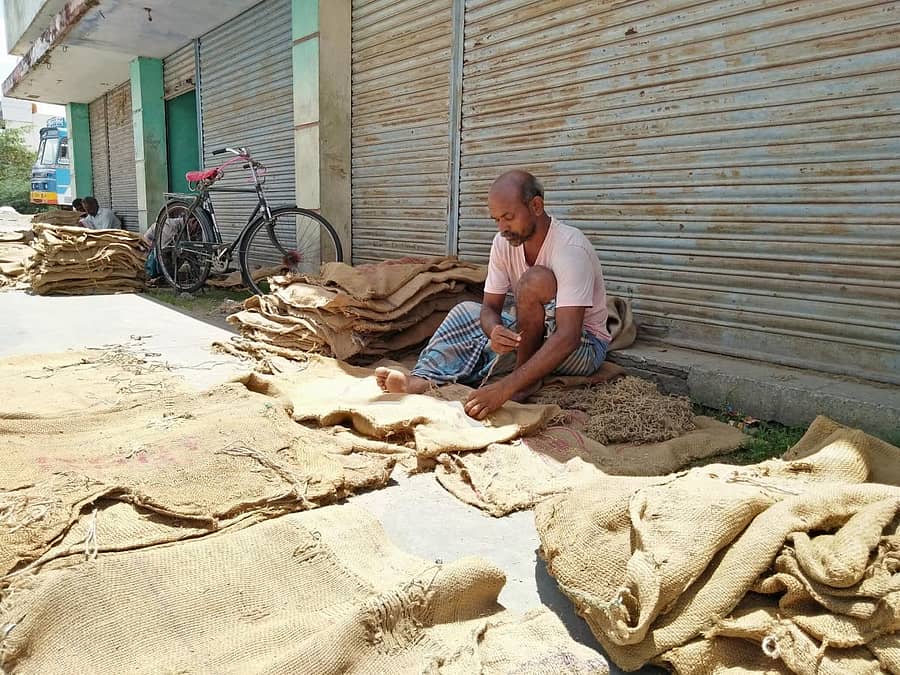 ಗಂಗಾವತಿಯ ಎಪಿಎಂಸಿ ಯಾರ್ಡ್ನಲ್ಲಿ ಖಾಲಿ ಚೀಲ ಹೊಲಿಯುತ್ತಿರುವ ಕೂಲಿಕಾರ್ಮಿಕ ಹನುಮಂತಪ್ಪ