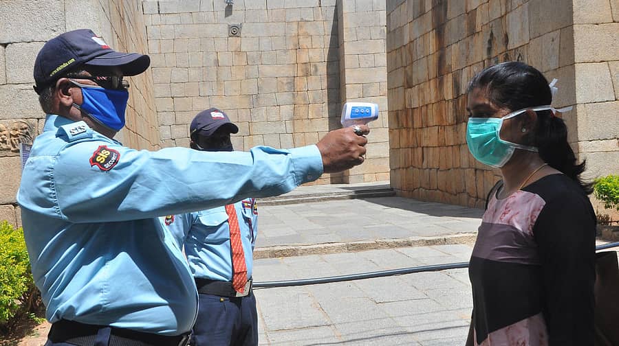 ಚಿತ್ರದುರ್ಗದ ಕೋಟೆಯೊಳಗಿನ ಸಂಪಿಗೆ ಸಿದ್ದೇಶ್ವರ ಸ್ವಾಮಿ ದರ್ಶನಕ್ಕಾಗಿ ಸೋಮವಾರ ದೇಗುಲಕ್ಕೆ ಹೊರಟಿದ್ದ ಭಕ್ತರೊಬ್ಬರನ್ನು ಥರ್ಮಲ್ ಸ್ಕ್ರೀನಿಂಗ್ ಮಾಡುತ್ತಿರುವ ಸಿಬ್ಬಂದಿ. ಚಿತ್ರ: ಭವಾನಿ ಮಂಜು.