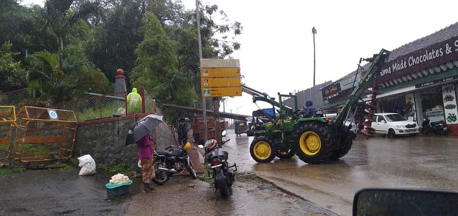 ಮಡಿಕೇರಿ ನಗರಸಭೆ ಪಕ್ಕ ಭಾನುವಾರ ವಿದ್ಯುತ್ ಕಂಬವೊಂದು ಗಾಳಿಗೆ ಉರುಳಿದ್ದು ಅದನ್ನು ದರುಸ್ತಿ ಪಡಿಸುವ ಕೆಲಸ ನಡೆಯಿತು