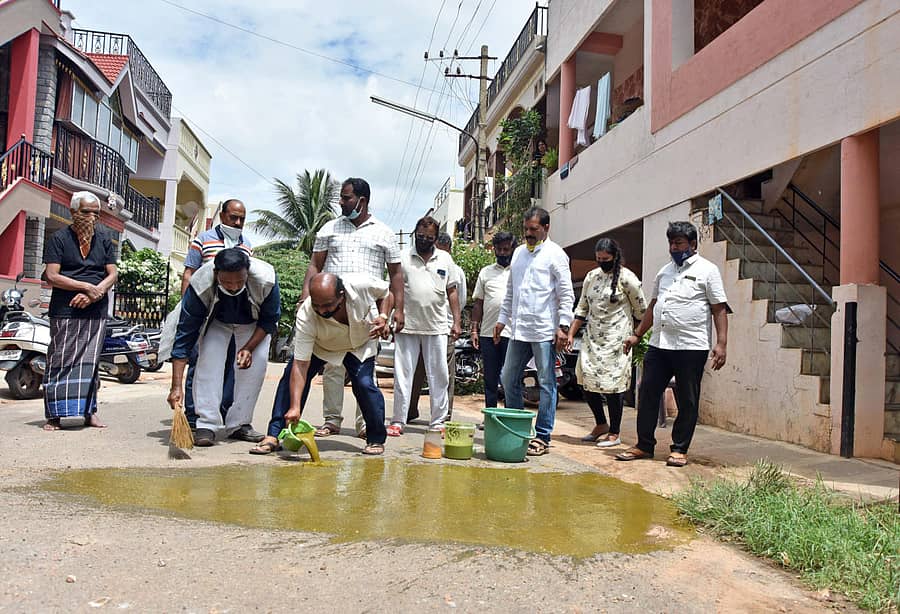 ಮೈಸೂರಿನ ಶಾರದಾ ದೇವಿ ನಗರದ ರಸ್ತೆಯಲ್ಲಿ ಹಿಂದುಳಿದ ವರ್ಗಗಳ ಜಾಗೃತಿ ವೇದಿಕೆಯ ರಾಜ್ಯ ಘಟಕದ ಅಧ್ಯಕ್ಷ ಕೆ.ಎಸ್.ಶಿವರಾಮು, ಕನ್ನಡ ಸಾಹಿತ್ಯ ಕಲಾಕೂಟದ ಅಧ್ಯಕ್ಷ ಎಂ.ಚಂದ್ರಶೇಖರ್ ಹಾಗೂ ಇತರರು ಕೊರೊನಾ ಸೋಂಕು ಮುಕ್ತಗೊಳಿಸಲು ಸೆಗಣಿಯ ಮಿಶ್ರಣದಿಂದ ಸ್ವಚ್ಛಗೊಳಿಸಿದರು