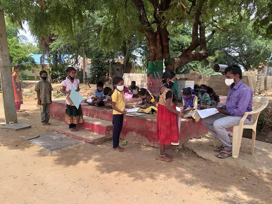 ಗಂಗಾವತಿ ತಾಲ್ಲೂಕಿನ ಲಕ್ಷ್ಮೀಕ್ಯಾಂಪ್ ಕುಂಟೋಜಿ ಗ್ರಾಮದ ದೇವರ ಕಟ್ಟೆ ಮೇಲೆ ಮಕ್ಕಳಿಗೆ ಪಾಠ ಮಾಡುತ್ತಿರುವ ಶಿಕ್ಷಕ ಸೋಮು ಕುದರಿಹಾಳ