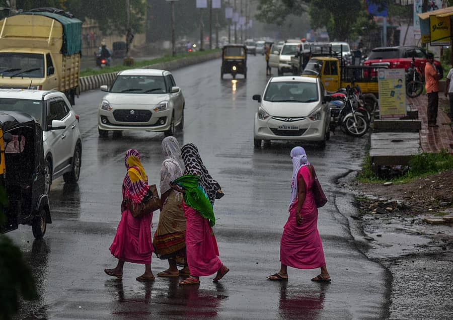 ಕಲಬುರ್ಗಿಯಲ್ಲಿ ಬುಧವಾರ ಸುರಿದ ಮಳೆಯಲ್ಲೇ ಆಶಾ ಕಾರ್ಯಕರ್ತೆಯರು ರಸ್ತೆ ದಾಟಿದರು