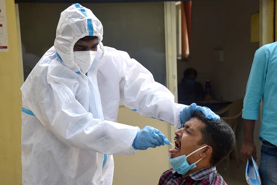 ಬೆಂಗಳೂರಿನ ಸಜ್ಜನ್ರಾವ್ ವೃತ್ತದ ಸಮೀಪ ಆರೋಗ್ಯ ಇಲಾಖೆ ಸಿಬ್ಬಂದಿ, ವ್ಯಕ್ತಿಯೊಬ್ಬರ ಗಂಟಲ ದ್ರವದ ಮಾದರಿ ಪಡೆಯುತ್ತಿರುವುದು –ಪ್ರಜಾವಾಣಿ ಚಿತ್ರ