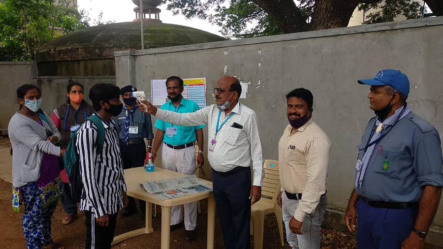 ರಾಮನಗರದ ಪರೀಕ್ಷಾ ಕೇಂದ್ರದಲ್ಲಿ ಬಿಇಒ ಮರೀಗೌಡ ವಿದ್ಯಾರ್ಥಿಗಳ ದೇಹದ ಉಷ್ಣತೆ ತಪಾಸಣೆ ಮಾಡಿದರು