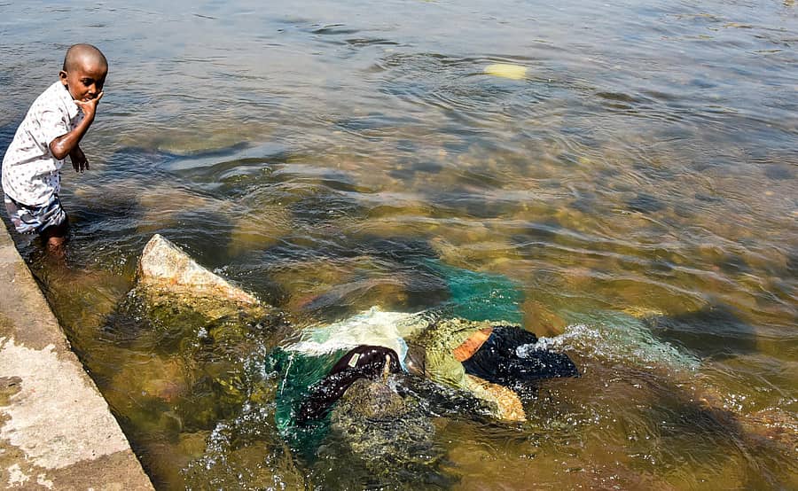 ಮಂಡ್ಯ ಜಿಲ್ಲೆಯ ಶ್ರೀರಂಗಪಟ್ಟಣದ ಕಾವೇರಿ ನದಿ ತೀರದಲ್ಲಿ ಪ್ರವಾಸಿಗರು ಪೂಜಾ ಸಾಮಗ್ರಿ ಮತ್ತು ಬಟ್ಟೆಗಳನ್ನು ನದಿಗೆ ಎಸೆದು ನದಿ ಕಲುಷಿತಗೊಂಡಿರುವ ದೃಶ್ಯ. ಚಿತ್ರ: ಬಿ.ಆರ್. ಸವಿತಾ