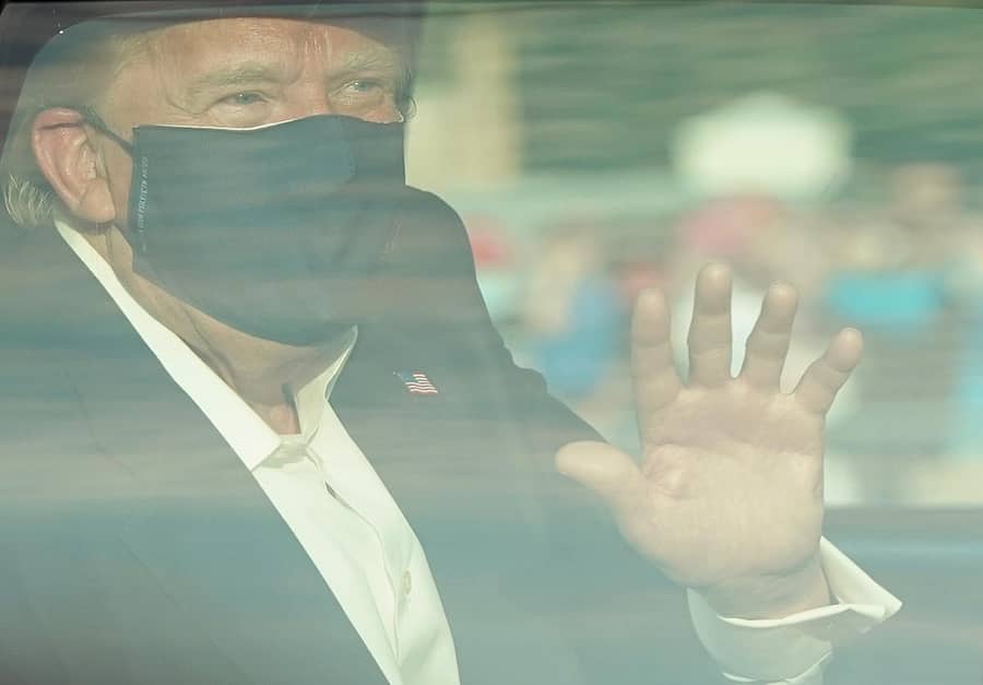 ಕಾರಿನಲ್ಲಿ ಕುಳಿತು ಜನರತ್ತ ಕೈ ಬೀಸುತ್ತಿರುವ ಟ್ರಂಪ್