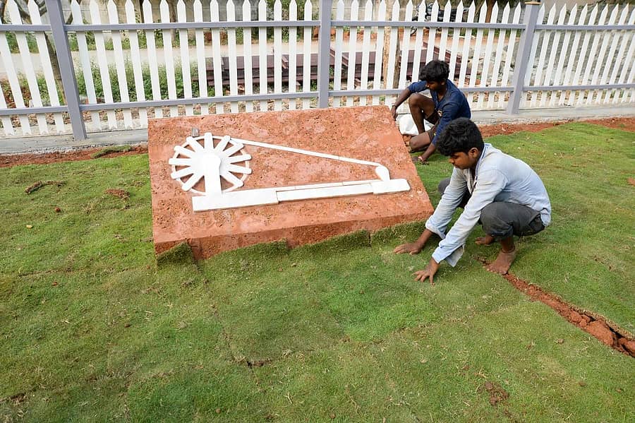 ಗಾಂಧಿಭವನದ ಎದುರು ಇರುವ ಚರಕದ ಸುತ್ತ ಹಸಿರು ಹಾಸುತ್ತಿರುವ ಕಾರ್ಮಿಕರು–ಪ್ರಜಾವಾಣಿ ಚಿತ್ರ/ ಸತೀಶ ಬಡಿಗೇರ್