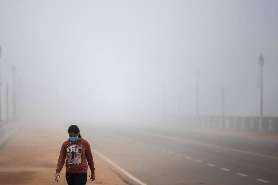 ನವದೆಹಲಿಯಲ್ಲಿ ಸೋಮವಾರ ಬೆಳಿಗ್ಗೆ ದಪ್ಪ ಮಂಜು ಆವರಿಸಿದ್ದು, ಮಂಜಿನ ನಡುವೆ ಮಹಿಳೆಯೊಬ್ಬರು ವಾಯುವಿಹಾರ ಮಾಡುತ್ತಿದ್ದಾರೆ.