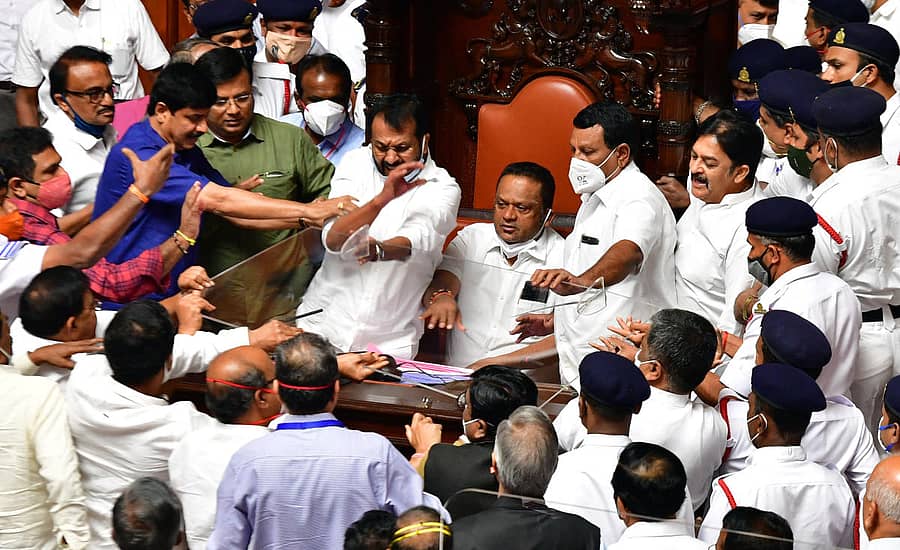 ಉಪಸಭಾಪತಿ ಎಸ್.ಎಲ್. ಧರ್ಮೇಗೌಡ ಅವರನ್ನು ಸಭಾಪತಿ ಪೀಠದಿಂದ ಬಲವಂತಾಗಿ ಎಬ್ಬಿಸಿ ಹೊರಗೆ ದೂಡಿದ ಕಾಂಗ್ರೆಸ್ ಸದಸ್ಯರು ತಕ್ಷಣವೇ ಪೀಠದಲ್ಲಿ ಚಂದ್ರಶೇಖರ ಪಾಟೀಲ ಅವರನ್ನು ಕೂರಿಸಿದರು. ಬಿಜೆಪಿ ಸದಸ್ಯರು ಪಾಟೀಲರನ್ನು ಎಬ್ಬಿಸದಂತೆ ತಡೆಯಲು ಕಾವಲಾಗಿ ನಿಂತಿರುವ ಕಾಂಗ್ರೆಸ್ ಸದಸ್ಯರು. –ಪ್ರಜಾವಾಣಿ ಚಿತ್ರ