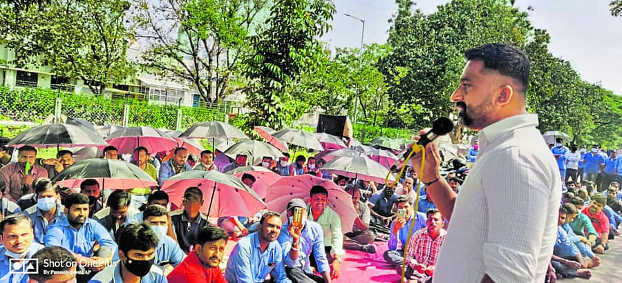 ಟಿಕೆಎಂ ಕಾರ್ಮಿಕರು ಮಂಗಳವಾರ ಕಾರ್ಖಾನೆ ಮುಂಭಾಗ ಛತ್ರಿ ಹಿಡಿದು ಪ್ರತಿಭಟನೆ ನಡೆಸಿದರು