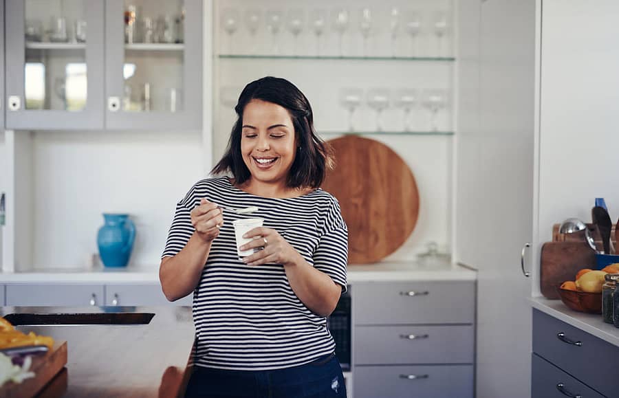 Shot of an attractive young woman eating yogurt at homeAs tasty as it is healthy
