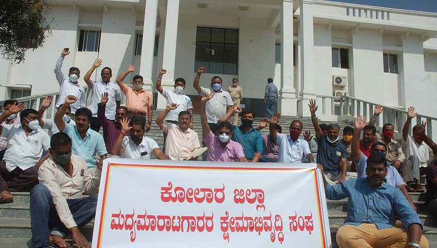 ವಿವಿಧ ಬೇಡಿಕೆ ಈಡೇರಿಕೆಗೆ ಒತ್ತಾಯಿಸಿ ಜಿಲ್ಲಾ ಮದ್ಯ ಮಾರಾಟಗಾರರ ಕ್ಷೇಮಾಭಿವೃದ್ಧಿ ಸಂಘದ ಸದಸ್ಯರು ಕೋಲಾರ ಜಿಲ್ಲಾಧಿಕಾರಿ ಕಚೇರಿ ಎದುರು ಮಂಗಳವಾರ ಧರಣಿ ನಡೆಸಿದರು.