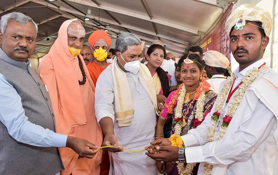 ನಂಜನಗೂಡು ತಾಲ್ಲೂಕಿನ ಸುತ್ತೂರು ಮಠದಲ್ಲಿ ಮಂಗಳವಾರ ನಡೆದ ಮಾಸಿಕ ಸಾಮೂಹಿಕ ವಿವಾಹ ಮಹೋತ್ಸವದಲ್ಲಿ ಭಾಗಿಯಾದ ವಧು, ವರರಿಗೆ ಸಚಿವ ಎಸ್.ಟಿ.ಸೋಮಶೇಖರ್, ಸುತ್ತೂರು ಮಠದ ಶಿವರಾತ್ರಿದೇಶಿಕೇಂದ್ರ ಸ್ವಾಮೀಜಿ, ವಿರೋಧ ಪಕ್ಷದ ನಾಯಕ ಸಿದ್ದರಾಮಯ್ಯ ಮಂಗಳಸೂತ್ರವನ್ನು ನೀಡಿದರು. ತುಮಕೂರಿನ ಸಿದ್ಧಗಂಗಾ ಮಠದ ಸಿದ್ಧಲಿಂಗ ಸ್ವಾಮೀಜಿ, ಕೆಪಿಸಿಸಿ ರಾಜ್ಯ ಮಹಿಳಾ ಘಟಕದ ಅಧ್ಯಕ್ಷೆ ಪುಷ್ಪಾ ಅಮರನಾಥ್ ಇದ್ದಾರೆ