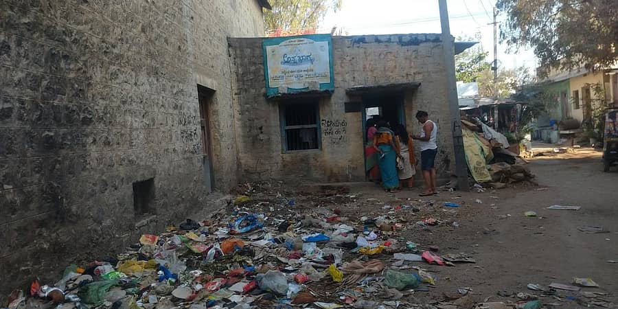ಕಸದ ರಾಶಿ ನಡುವೆ ಪಡಿತರ ಧಾನ್ಯ ಪಡೆಯುತ್ತಿರುವ ಜನ