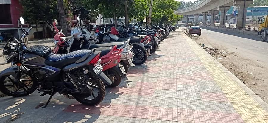 ವಾಹನ ನಿಲುಗಡೆಯಾಗಿ ಬದಲಾಗಿರುವ ಅರವಿಂದ್ ಗಾರ್ಮೆಂಟ್ಸ್ ಬಳಿಯ ಪಾದಚಾರಿ ಮಾರ್ಗ