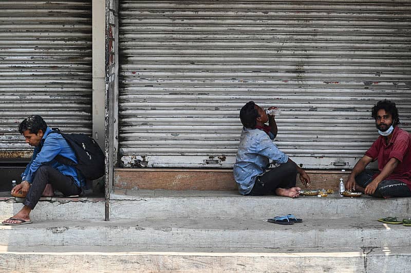 ಮುಂಬೈನಲ್ಲಿ ವಾರಾಂತ್ಯದ ಲಾಕ್ಡೌನ್ ಸಂದರ್ಭದಲ್ಲಿ ಮುಚ್ಚಿರುವ ಅಂಗಡಿಗಳ ಮುಂದೆ ಕುಳಿತು ಆಹಾರ ಸೇವಿಸುತ್ತಿರುವ ಕಾರ್ಮಿಕರು