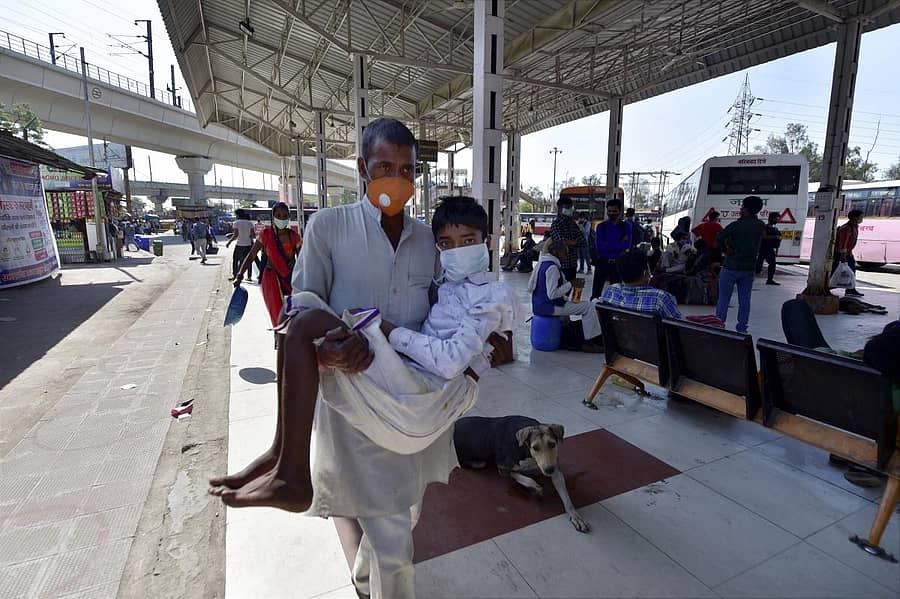 ಉತ್ತರಪ್ರದೇಶದ ಗಾಜಿಯಾಬಾದ್ನ ಬಸ್ನಿಲ್ದಾಣದಲ್ಲಿ ವ್ಯಕ್ತಿಯೊಬ್ಬರು ತಮ್ಮ ಕಾಯಿಲೆಪೀಡಿತ ಮಗನನ್ನು ಹೊತ್ತು ನಡೆದರು -ಪಿಟಿಐ ಚಿತ್ರ