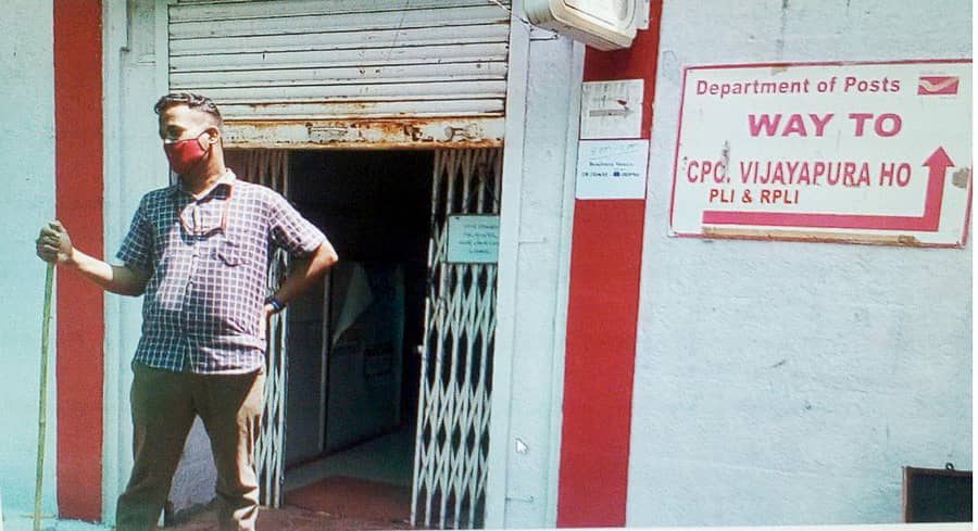 ವಿಜಯಪುರ ನಗರದ ಕೇಂದ್ರ ಅಂಚೆ ಕಚೇರಿ ಪ್ರವೇಶ ದ್ವಾರದಲ್ಲಿ ಕೈಯಲ್ಲಿ ಬಡಿಗೆ ಹಿಡಿದು ನಿಲ್ಲುತ್ತಿರುವ ಇಲಾಖೆ ಸಿಬ್ಬಂದಿ