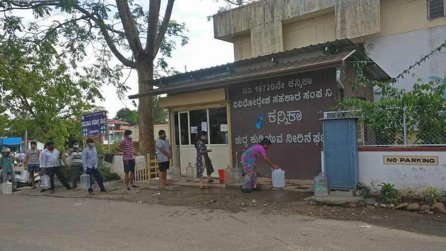 ಕುಶಾಲನಗರ ಆಸ್ಪತ್ರೆ ಬಳಿಯ ಶುದ್ಧ ಕುಡಿಯುವ ನೀರಿನ ಘಟಕದ ಮುಂದೆ ಸರತಿ ಸಾಲಿನಲ್ಲಿ ನಿಂತಿರುವ ಜನ