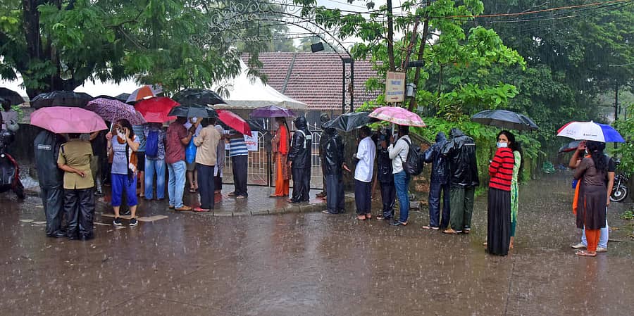 ಮಂಗಳೂರು ಬಿಜೈ ಕಾಪಿಕಾಡ್ ಸರ್ಕಾರಿ ಶಾಲೆಯ ಎದುರು ಲಸಿಕೆಗಾಗಿ ಜನರು ಮಳೆಯಲ್ಲಿ ಸಾಲಿನಲ್ಲಿ ನಿಂತಿದ್ದರು.