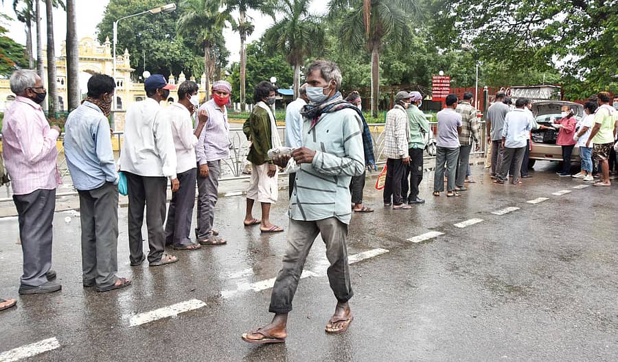 ಬೀಳುತ್ತಿದ್ದ ಮಳೆಯ ನಡುವೆಯೇ ನಿರಾಶ್ರಿತರು, ರಸ್ತೆಬದಿ ಮಲಗುವವರು, ಆಸ್ಪತ್ರೆಗಳಲ್ಲಿ ದಾಖಲಾದ ರೋಗಿಗಳ ಸಂಬಂಧಿಕರು ದಾನಿಗಳು ಹಂಚುತ್ತಿದ್ದ ಆಹಾರ ಪೊಟ್ಟಣಗಳನ್ನು ಮೈಸೂರು ಅರಮನೆ ಸಮೀಪ ಬುಧವಾರ ಪಡೆದುಕೊಂಡರು