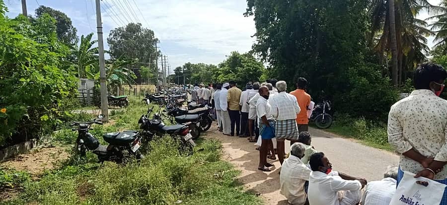 ಹಂದನಕೆರೆ ರೈತ ಸಂಪರ್ಕ ಕೇಂದ್ರದ ಮುಂದೆ ಟಾರ್ಪಲ್ಗಾಗಿ ನಿಂತಿದ್ದ ರೈತರು