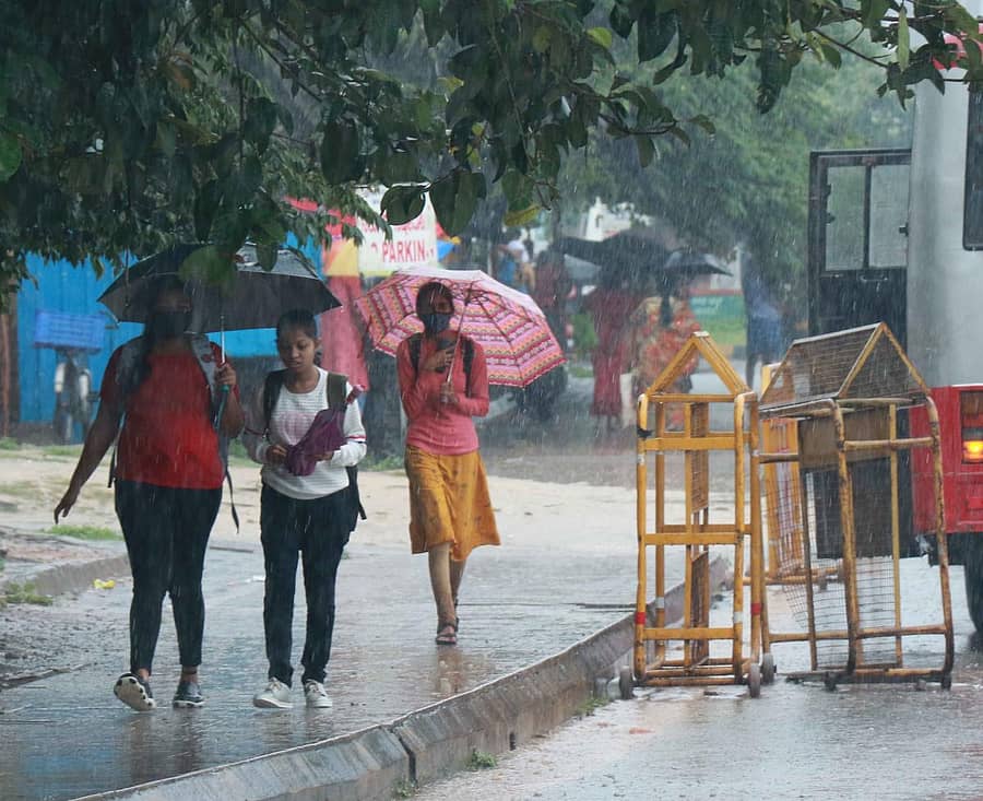 ಹಾಸನದಲ್ಲಿ ಶುಕ್ರವಾರ ಸುರಿದ ಮಳೆ ವೇಳೆ ಯುವತಿಯರು ಕೊಡೆ ಹಿಡಿದು ಸಾಗುತ್ತಿರುವ ದೃಶ್ಯ.