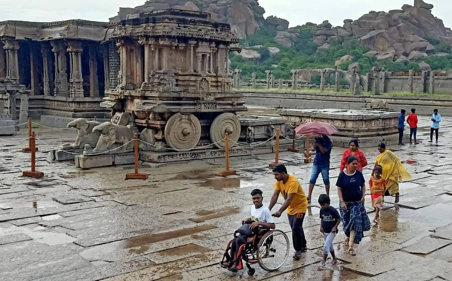 ಪ್ರವಾಸಿಗರು ಗುರುವಾರ ಮಳೆಯಲ್ಲೇ ನೆನೆದುಕೊಂಡು ಹಂಪಿ ಕಲ್ಲಿನ ರಥ ವೀಕ್ಷಿಸಿದರು