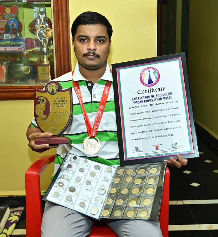 ‘ವರ್ಲ್ಡ್ ರೆಕಾರ್ಡ್ ಇಂಡಿಯಾ– 2021’ರ ಪ್ರಮಾಣ ಪತ್ರ, ಪ್ರಶಸ್ತಿ ಹಾಗೂ ತಮ್ಮ ಸಂಗ್ರಹದ ನಾಣ್ಯಗಳೊಂದಿಗೆ ಕಾರವಾರದ ಶೇಜವಾಡದ ವಾಸುದೇವ ಅನಂತ ಹರ್ಚಿಕರ್