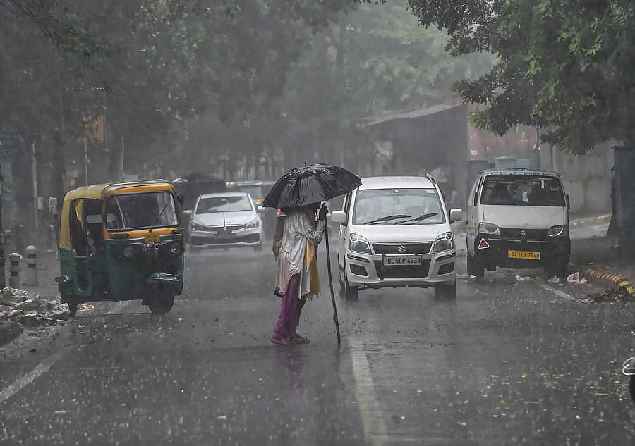 ನವದೆಹಲಿಯಲ್ಲಿ ಮಂಗಳವಾರ ಸುರಿದ ಭಾರಿ ಮಳೆಯಿಂದ ರಕ್ಷಿಸಿಕೊಳ್ಳಲು ವ್ಯಕ್ತಿಯೊಬ್ಬ ಕೊಡೆಯ ರಕ್ಷಣೆ ಪಡೆದಿರುವ ದೃಶ್ಯ.