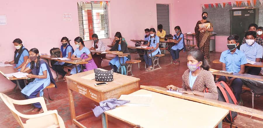 ಚಾಮರಾಜನಗರದ ಉಪ್ಪಾರ ಬೀದಿಯಲ್ಲಿರುವ ಸರ್ಕಾರಿ ಹಿರಿಯ ಪ್ರಾಥಮಿಕ ಶಾಲೆಯಲ್ಲಿ ಸುರಕ್ಷಿತ ಅಂತರಕಾಯ್ದುಕೊಂಡು ತರಗತಿಯಲ್ಲಿ ಪಾಠ ಕೇಳಿದ 8ನೇ ತರಗತಿ ವಿದ್ಯಾರ್ಥಿಗಳು