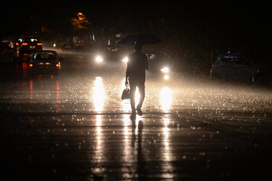 ದಾವಣಗೆರೆಯ ಶಾಮನೂರು ರಸ್ತೆಯಲ್ಲಿ ಸೋಮವಾರ ರಾತ್ರಿ ಸುರಿದ ಜೋರು ಮಳೆಯ ನಡುವೆ ಪಾದಚಾರಿಯೊಬ್ಬರು ಸಂಚರಿಸಿದ್ದು ಹೀಗೆ –ಪ್ರಜಾವಾಣಿ ಚಿತ್ರ/ ಸತೀಶ ಬಡಿಗೇರ್