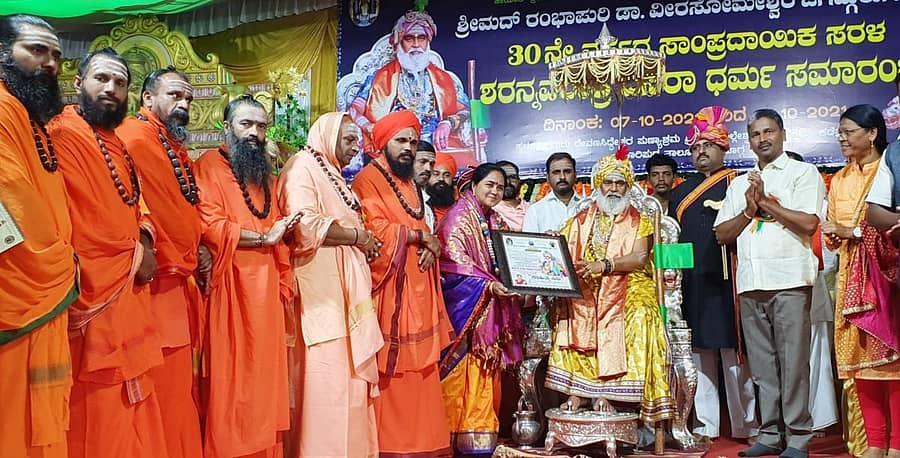 ಶಿರಾಳಕೊಪ್ಪ ಸಮೀಪದ ಕಡೇನಂದಿಹಳ್ಳಿಯಲ್ಲಿ ನಡೆಯುತ್ತಿರುವ ರಂಭಾಪುರಿಶ್ರೀ ಶರನ್ನವರಾತ್ರಿ ದಸರಾ ದರ್ಬಾರ್ ಧರ್ಮ ಸಮಾರಂಭದಲ್ಲಿ ಲಕ್ಷ್ಮೇಶ್ವರದ ಡಾ. ಜಯಶ್ರೀ ಮಲ್ಲಿಕಾರ್ಜುನ ಹೊಸಮನಿ ಅವರಿಗೆ ರಂಭಾಪುರಿಶ್ರೀ ‘ಸಾಹಿತ್ಯ ಸಿರಿ’ ಪ್ರಶಸ್ತಿ ಪ್ರದಾನ ಮಾಡಿದರು. ಮಠಾಧೀಶರು ಇದ್ದರು.