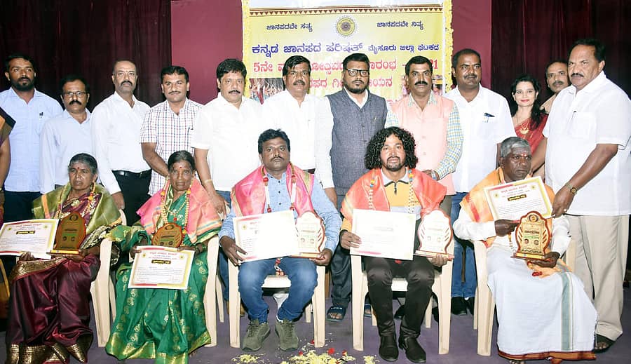 ಮೈಸೂರಿನ ಮನೆಯಂಗಳದಲ್ಲಿ ನಡೆದ ಕನ್ನಡ ಜಾನಪದ ಪರಿಷತ್‌ನ ಮೈಸೂರು ಜಿಲ್ಲಾ ಘಟಕದ ಐದನೇ ವಾರ್ಷಿಕೋತ್ಸವದಲ್ಲಿ ಬನ್ನೂರಿನ ಸೋಬಾನೆ ಹಾಡುಗಾರ್ತಿಯರಾದ ಜಯಮ್ಮ, ಚಿಕ್ಕತಾಯಮ್ಮ, ಗಾಯಕರಾದ ಮರಿಸ್ವಾಮಿ ಹಂಸ, ಅಮ್ಮ ರಾಮಚಂದ್ರ, ಮಹದೇವ ಅವರನ್ನು ಜಿಲ್ಲಾ ಪಂಚಾಯಿತಿಯ ಮಾಜಿ ಅಧ್ಯಕ್ಷ ಕೆ.ಮರಿಗೌಡ ಸನ್ಮಾನಿಸಿದರು