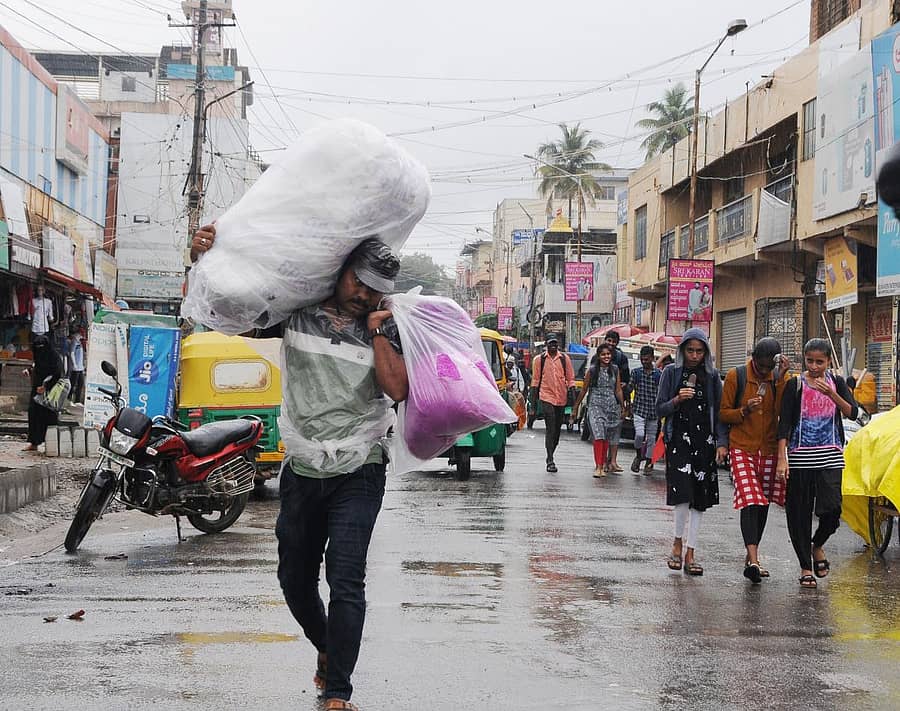 ತುಮಕೂರಿನಲ್ಲಿ ವ್ಯಕ್ತಿಯೊಬ್ಬರು ಮಳೆಯಲ್ಲೇ ಚೀಲ ಹೊತ್ತು ಸಾಗಿದರು (ಎಡಚಿತ್ರ) ಛತ್ರಿ ಹಿಡಿದು ಮಳೆಯಲ್ಲೇ ಹೆಜ್ಜೆ ಹಾಕಿದ ಯುವತಿಯರು