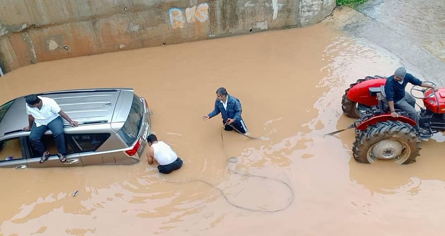 ಆನೇಕಲ್ ತಾಲ್ಲೂಕಿನ ಅರವಂಟಿಕೆಪುರ ರೈಲ್ವೆ ಅಂಡರ್ಪಾಸ್ ಬಳಿ ಸಿಲುಕಿಕೊಂಡಿದ್ದ ಕಾರನ್ನು ಟ್ರಾಕ್ಟರ್ ಮೂಲಕ ಹೊರ ತೆಗೆಯಲಾಯಿತು