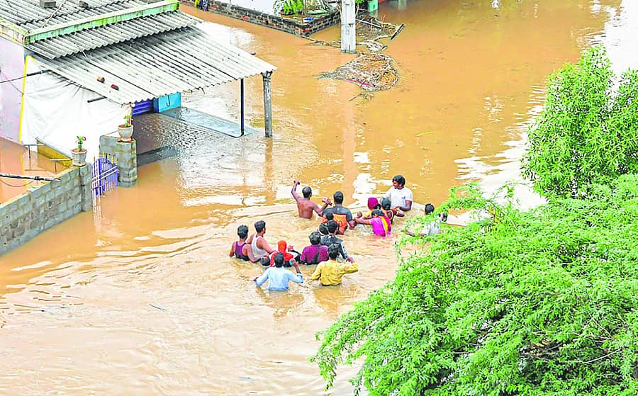 ಆಂಧ್ರಪ್ರದೇಶದ ನೆಲ್ಲೂರು ಜಿಲ್ಲೆಯಲ್ಲಿ ಜಲಾವೃತಗೊಂಡ ರಸ್ತೆಯಲ್ಲೇ ಜನರು ಸಾಗಿದರು –ಪಿಟಿಐ ಚಿತ್ರ