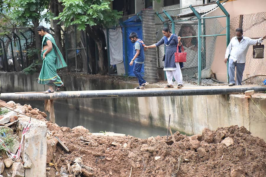 ಮಲ್ಲೇಶ್ವರದ ದತ್ತಾತ್ರೇಯ ದೇವಸ್ಥಾನದ ಬಳಿ ರಾಜಕಾಲುವೆ ಮೇಲೆ ಹಾಕಿರುವ ಪೈಪ್ಗಳ ಮೇಲೆ ಕಷ್ಟಪಟ್ಟು ದಾಟುತ್ತಿರುವ ಸ್ಥಳೀಯರು –ಪ್ರಜಾವಾಣಿ ಚಿತ್ರ/ಬಿ.ಕೆ.ಜನಾರ್ದನ್