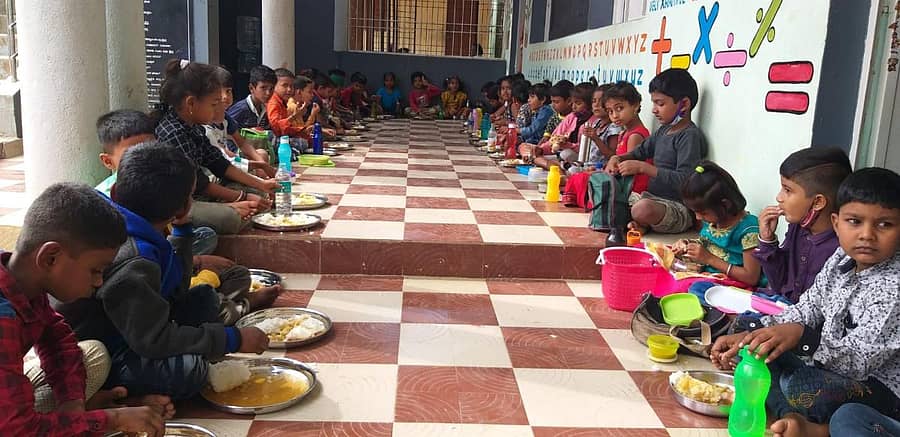 ಶಾಲೆಯ ಆವರಣದಲ್ಲಿ ಬಿಸಿಯೂಟ ಸವಿಯುತ್ತಿರುವ ಮಕ್ಕಳು (ಸಂಗ್ರಹ ಚಿತ್ರ)