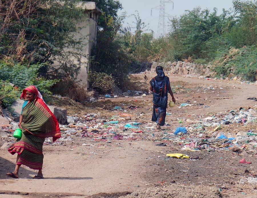 ಲಿಂಗಸುಗೂರು ಪುರಸಭೆ ವ್ಯಾಪ್ತಿಯ ಕರಡಕಲ್ಲ ಗ್ರಾಮದ ತ್ಯಾಜ್ಯ ತುಂಬಿರುವ ರಸ್ತೆಯಲ್ಲಿ ಬಯಲು ಬಹಿರ್ದೆಸೆಗೆ ತೆರಳುವ ಮಹಿಳೆಯರು