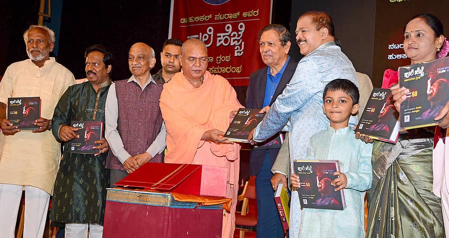 ಹುಲಿಕಲ್ ನಟರಾಜ್ (ಎಡದಿಂದ ಆರನೆಯವರು) ಅವರ ಅಭಿನಂದನಾ ಗ್ರಂಥ ‘ಹುಲಿ ಹೆಜ್ಜೆ’ಯನ್ನು ನಿಡುಮಾಮಿಡಿ ಮಠದ ವೀರಭದ್ರ ಚನ್ನಮಲ್ಲ ಸ್ವಾಮೀಜಿ (ಎಡದಿಂದ ನಾಲ್ಕನೆಯವರು) ಬಿಡುಗಡೆ ಮಾಡಿದರು. (ಎಡದಿಂದ) ಕುಂ. ವೀರಭದ್ರಪ್ಪ, ಚಲನಚಿತ್ರ ನಿರ್ದೇಶಕ ಟಿ.ಎಸ್. ನಾಗಾಭರಣ, ಎ.ಎಸ್. ಕಿರಣ್ ಕುಮಾರ್, ಲೋಕಾಯುಕ್ತ ನಿವೃತ್ತ ನ್ಯಾಯಮೂರ್ತಿ ಎನ್. ಸಂತೋಷ್ ಹೆಗ್ಡೆ, ಹುಲಿಕಲ್ ನಟರಾಜ್ ಅವರ ಮೊಮ್ಮಗ ಉದಾತ್ ಮತ್ತು ಪತ್ನಿ ದೇವಿಕಾ ಇದ್ದಾರೆ. -ಪ್ರಜಾವಾಣಿ ಚಿತ್ರ